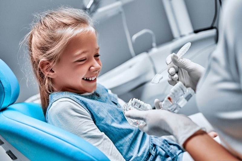 Young girl smiling during gentle pediatric dental treatment in Carrollton, TX