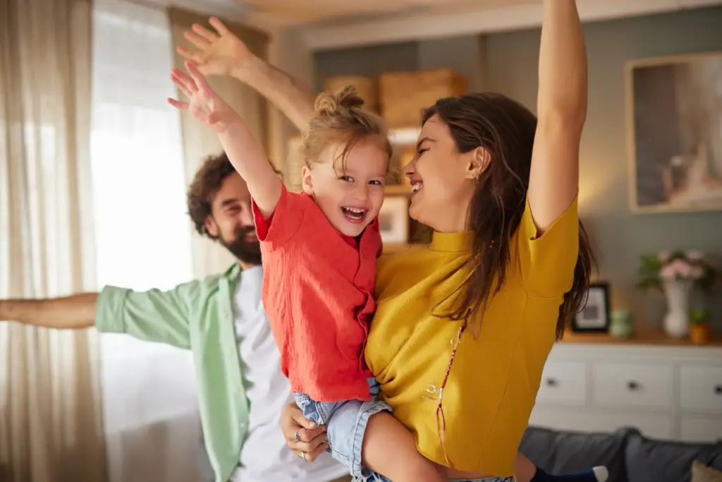Happy family with child, representing positive pediatric dental emergency care in Carrollton, TX