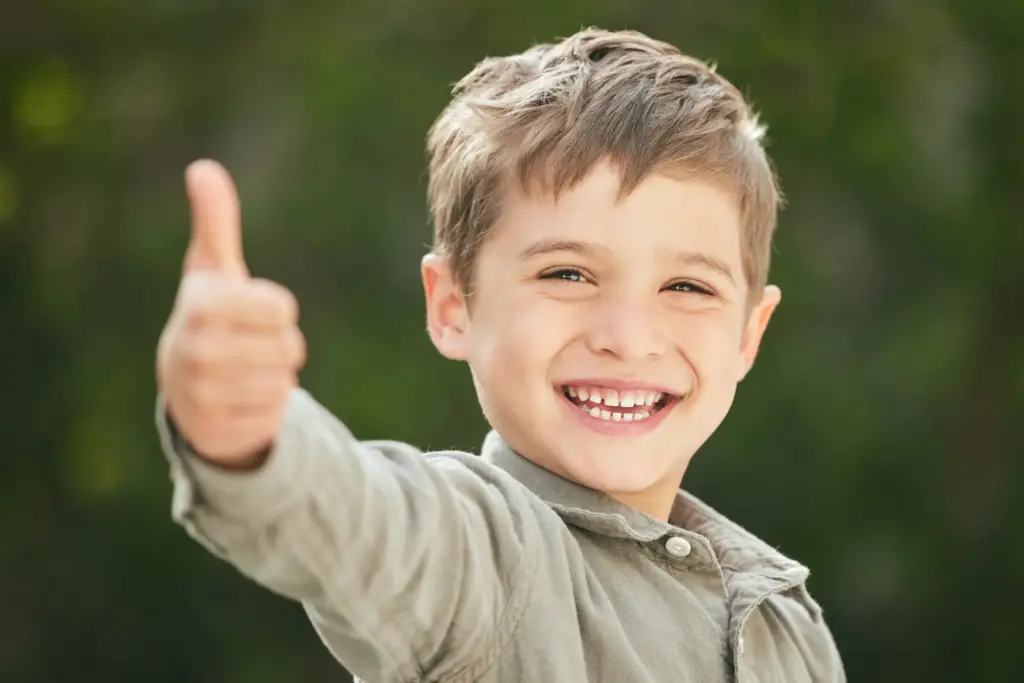 Happy child giving thumbs up after successful Pediatric Dental Crown in Carrollton, TX