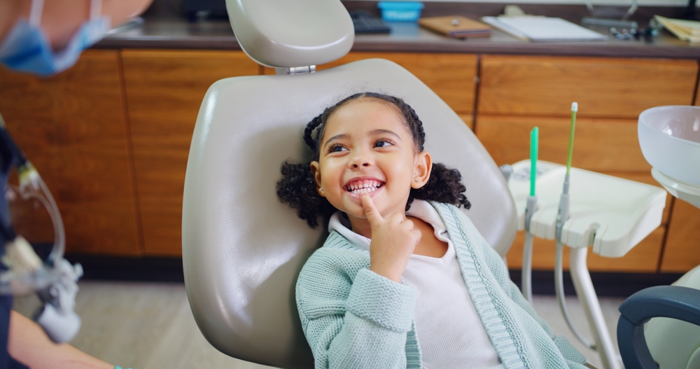 Happy child sitting in dental chair during pediatric dental visit in Carrollton, TX